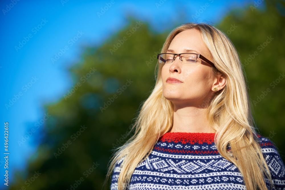 在冬日的阳光下享受奢华。一位迷人的年轻女子在户外享受一天的照片。