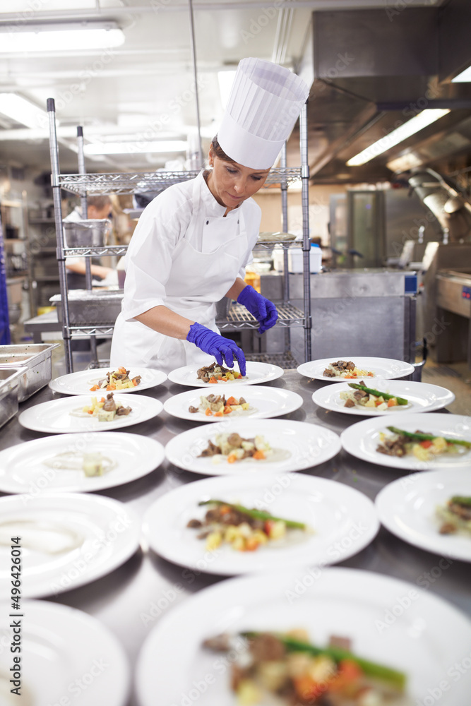 厨房里能干的双手。一位厨师在专业厨房为用餐服务准备食物的镜头