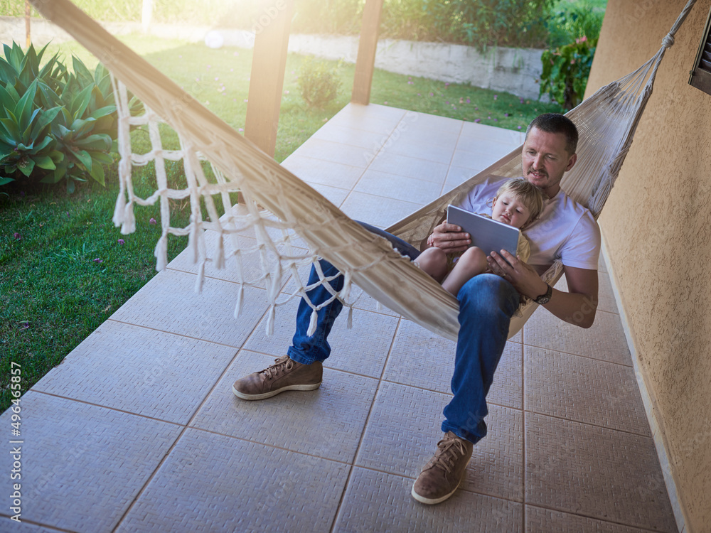 Its their comfy spot to get connected. Shot of a father and his little daughter using a digital tabl