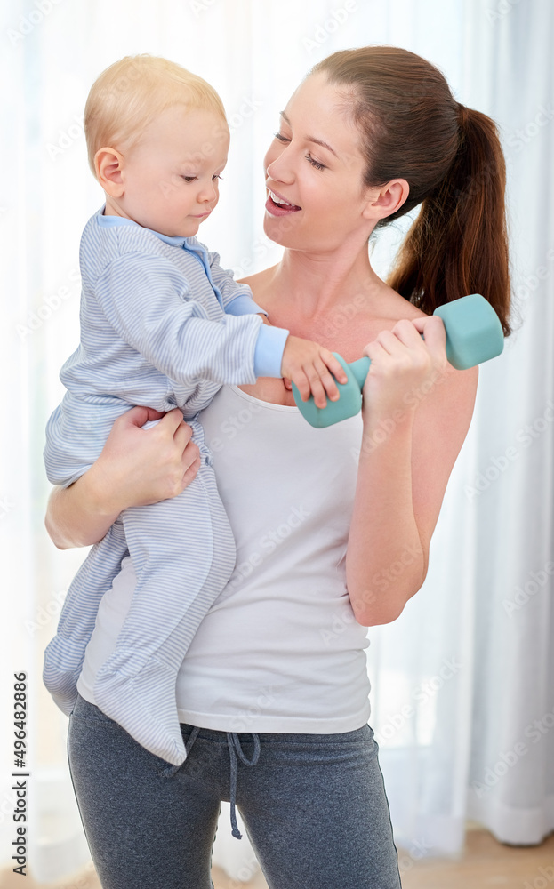 Youre going to be a strong young man. Shot of a young woman working out while spending time with her