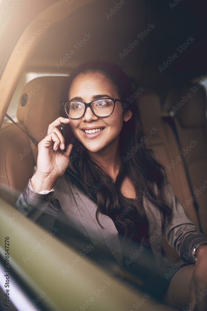 Success follows her wherever she goes. Shot of a young businesswoman talking on a cellphone in the b