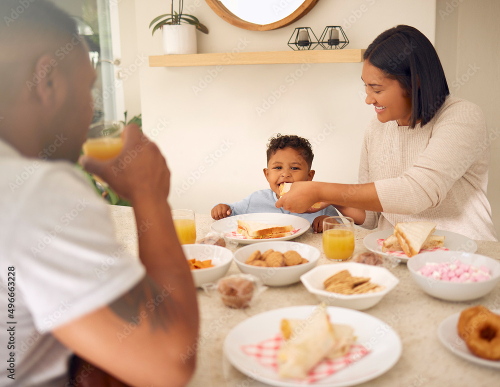 A little bite for my little boy. Shot of a happy young family having a leisurely lunch in their back