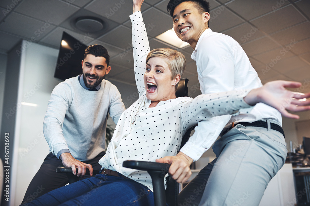 Having some colleague fun in the office. Shot of businesspeople having fun by pushing taking their c