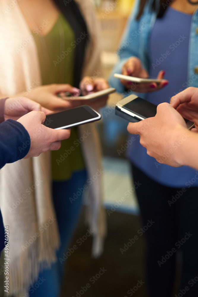 Let me check my calender. Shot of a group of unidentifiable friends using their smartphones together