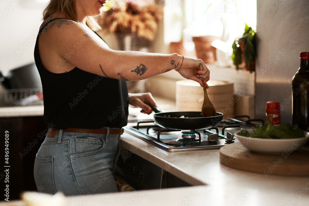 搅拌可以防止粘连。一个女人在家做饭的裁剪镜头。