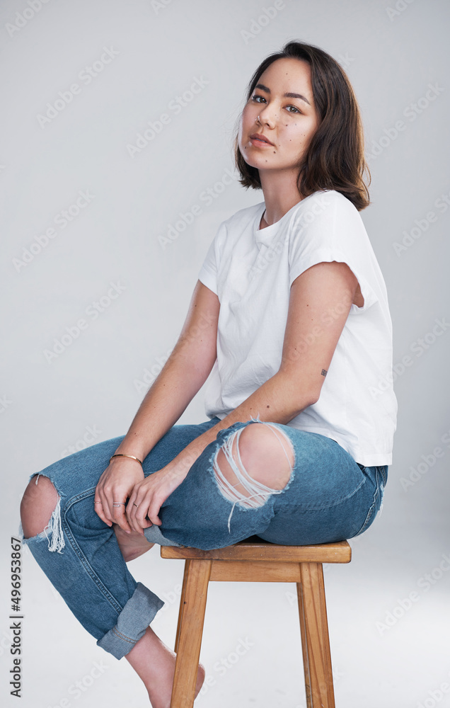 Keep it simple, keep it you. Cropped shot of a beautiful young woman sitting against a white backgro