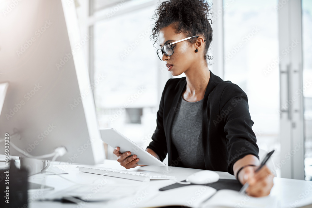 Productivity = success. Shot of a young businesswoman using a digital tablet, computer and writing n