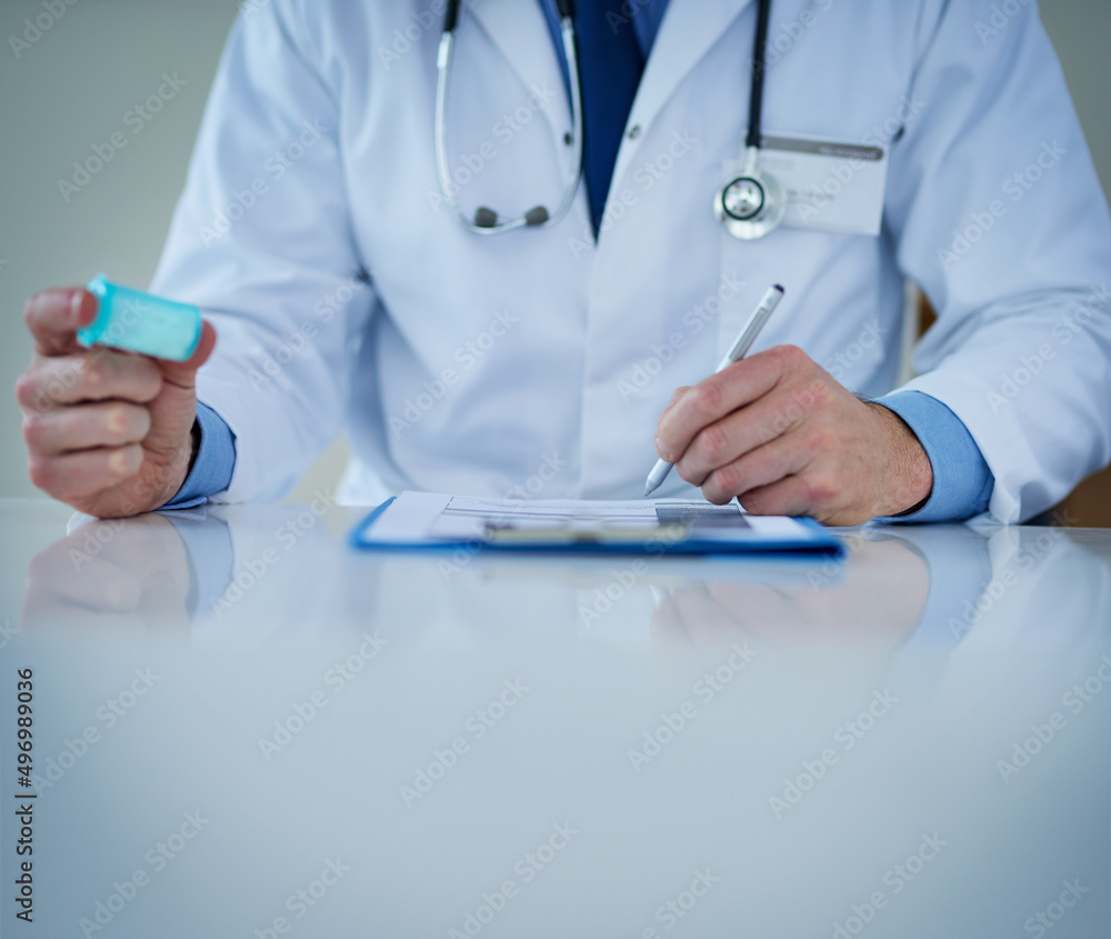 Keeping track of your health. Closeup shot of an unrecognizable doctor writing notes while holding a