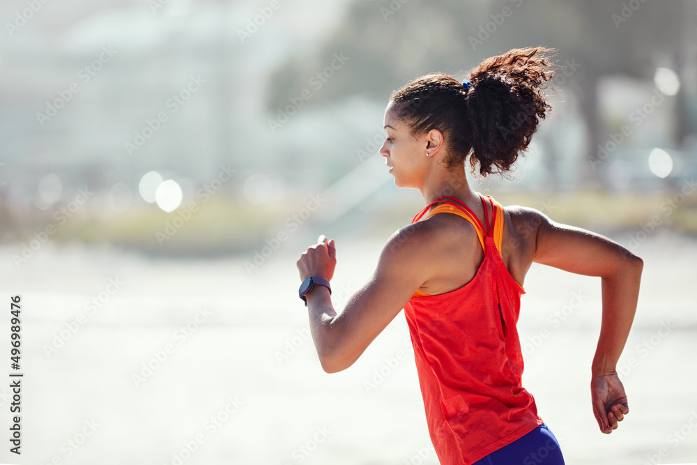 Dont dream of winning, train for it. Shot of a sporty young woman out at the beach for her morning r