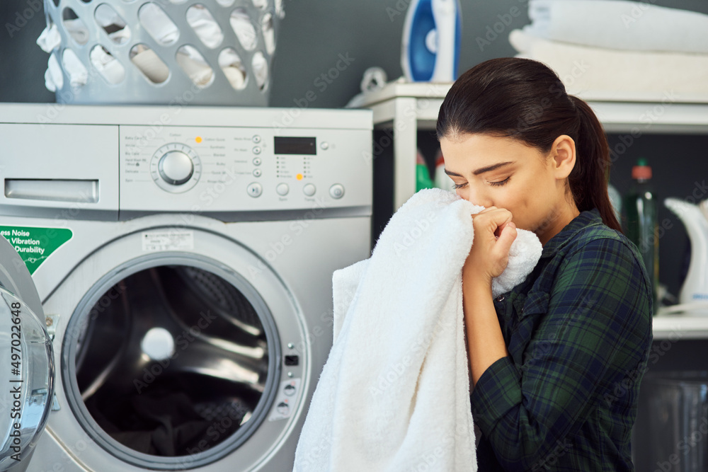 The smell of fresh laundry. Cropped shot of an attractive young woman smelling a freshly washed towe