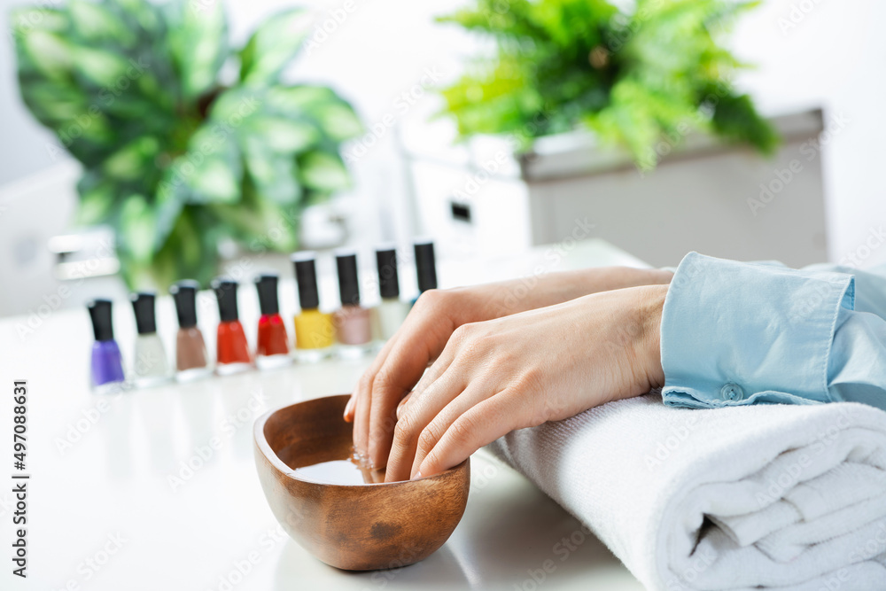 Closeup female hands in wooden bowl with water