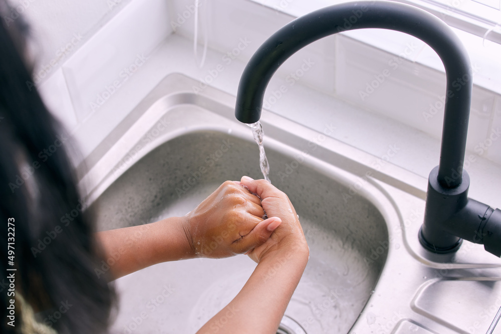 Clean hands= A healthier you. Cropped shot of an unrecognizable girl washing her hands by the kitche