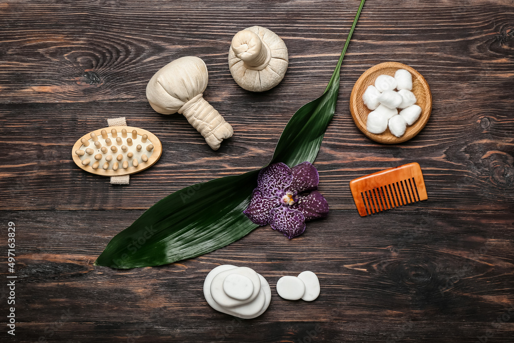 Spa composition with bathing supplies, stones and herbal bags on wooden background