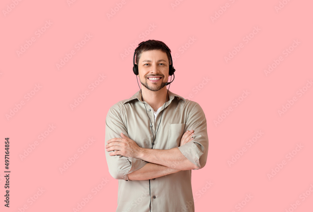 Smiling consultant of call center in headset on pink background