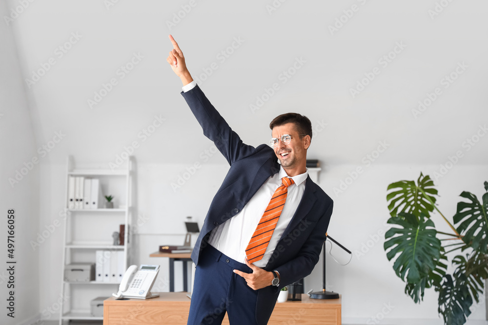 Dancing young businessman in office