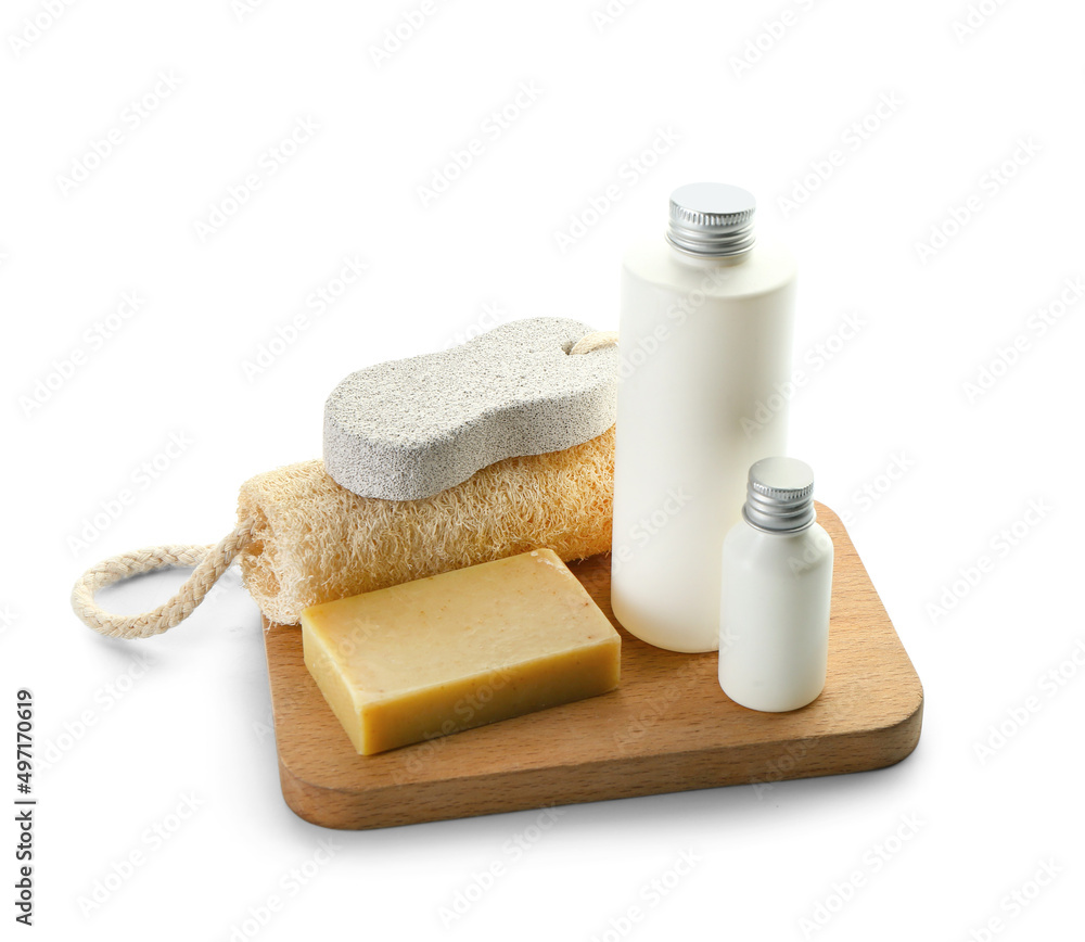 Wooden board with bottles of cosmetic products, soap, bath sponge and pumice on white background