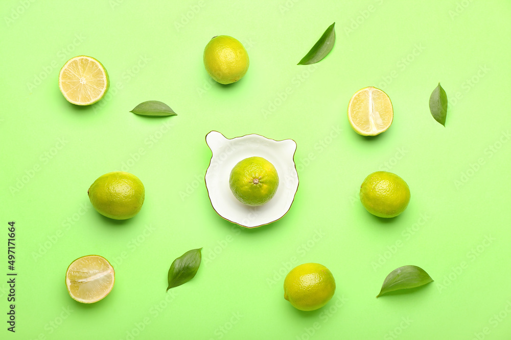 Ceramic juicer and limes on green background