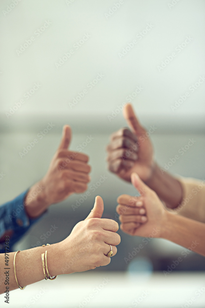 Youre doing great. Closeup shot of a group of businesspeople giving thumbs up together.