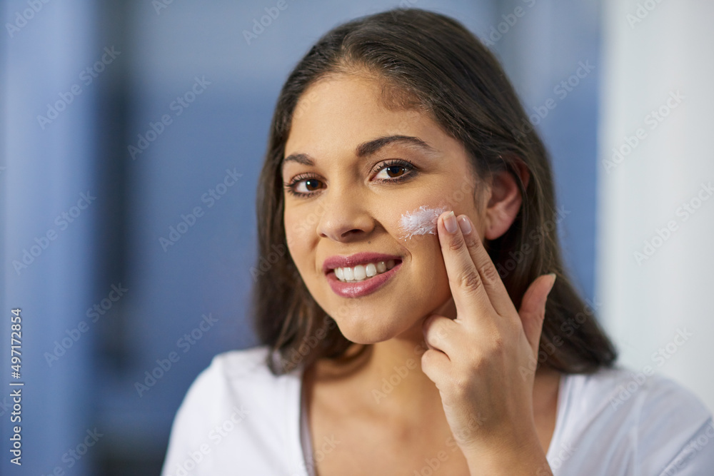 This is how I keep my skin soft and supple. Shot of an attractive young woman getting ready in her b