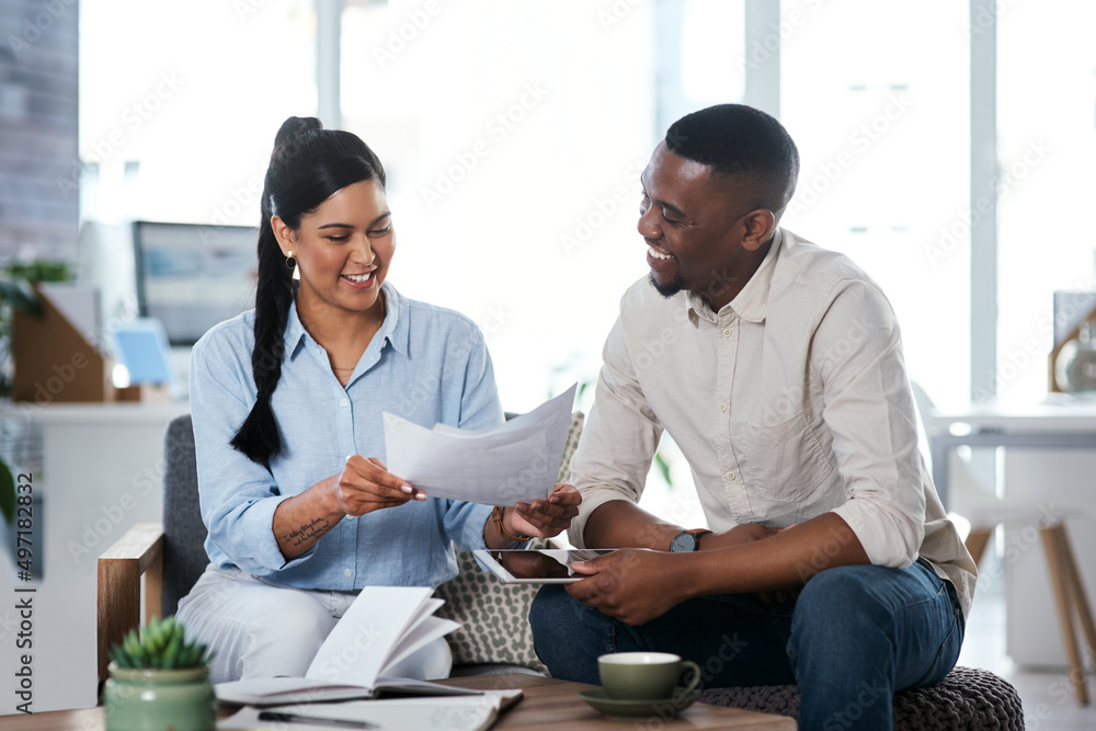 Stying productive and achieving it all. Shot of two businesspeople going through paperwork together 