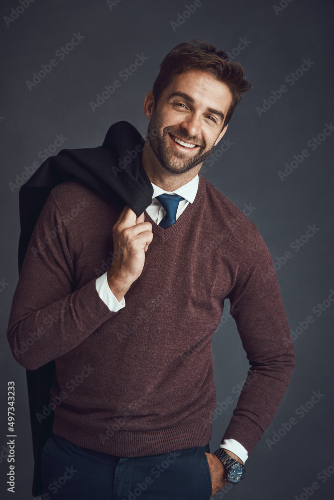 The style conscious man. Studio portrait of a stylishly dressed young man carrying his jacket agains