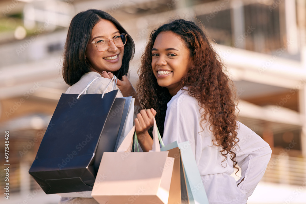 Bonding and retail therapy. Shot of two attractive young women standing outside together and bonding