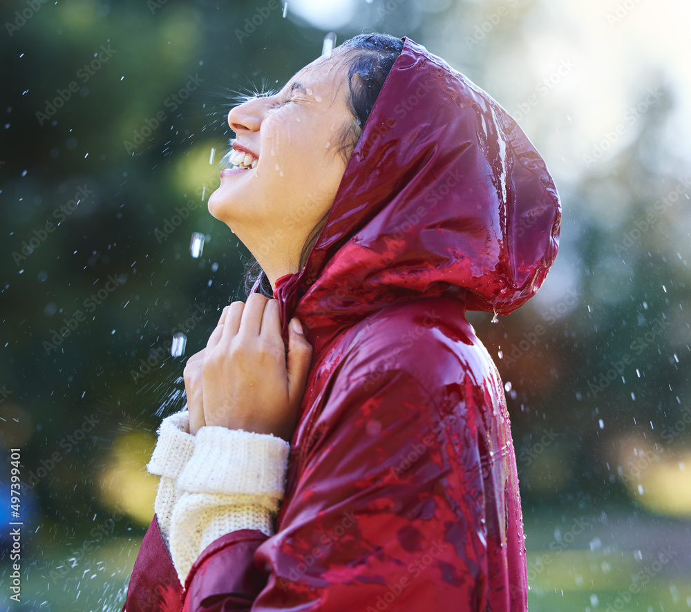 今天是享受生活的好日子。一个年轻女人在外面享受雨水的镜头。