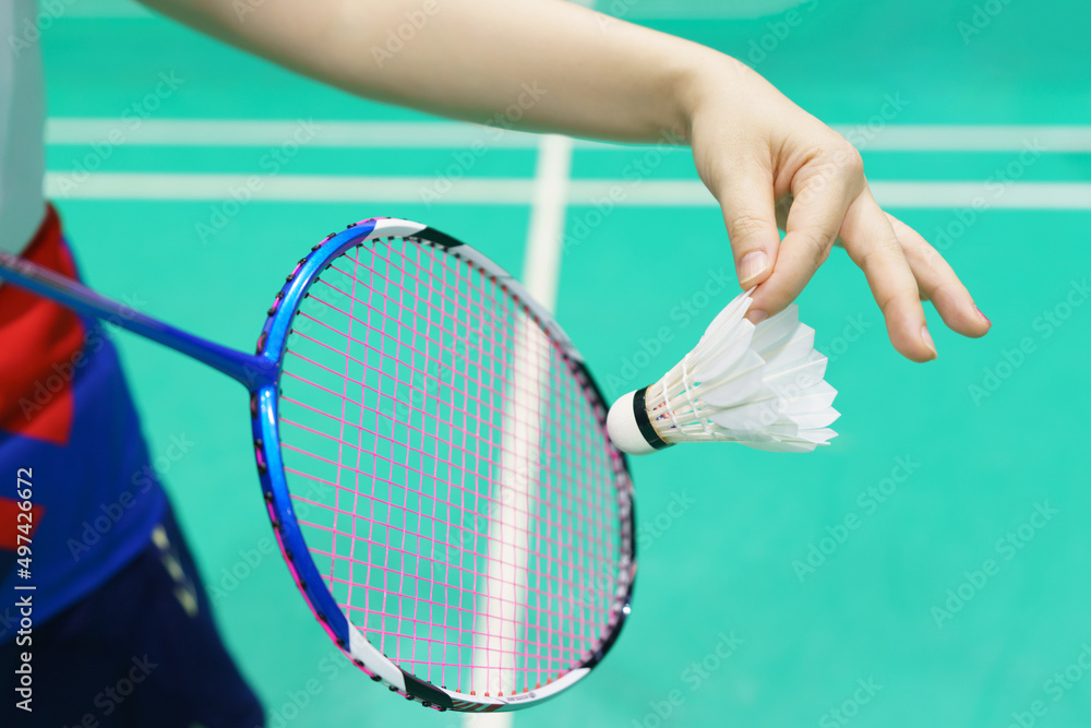 woman holding a badminton racket ready to hit shuttecock