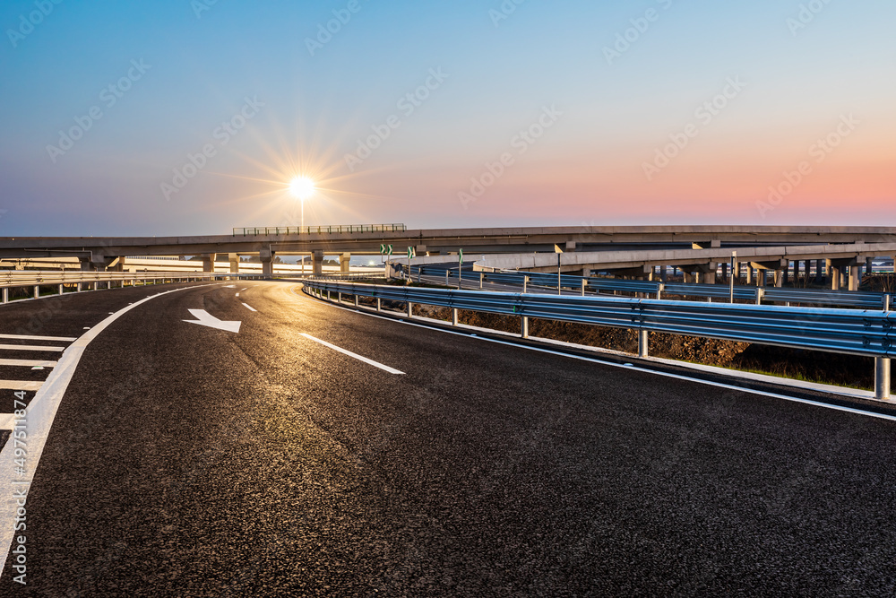 空旷的柏油公路和街灯，日落时天空美丽