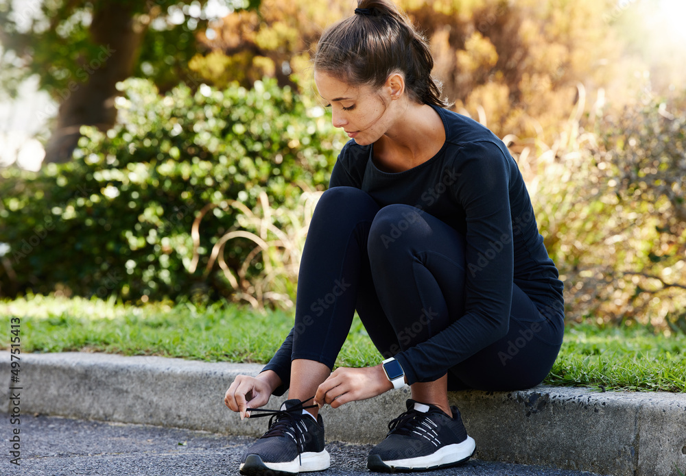 Making sure her laces are nice and tight. Full length shot of an attractive and athletic young woman