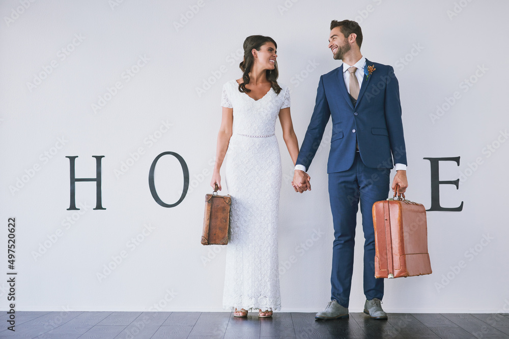 And so the adventure of marriage begins. Concept studio shot of a bride and groom making an M in the