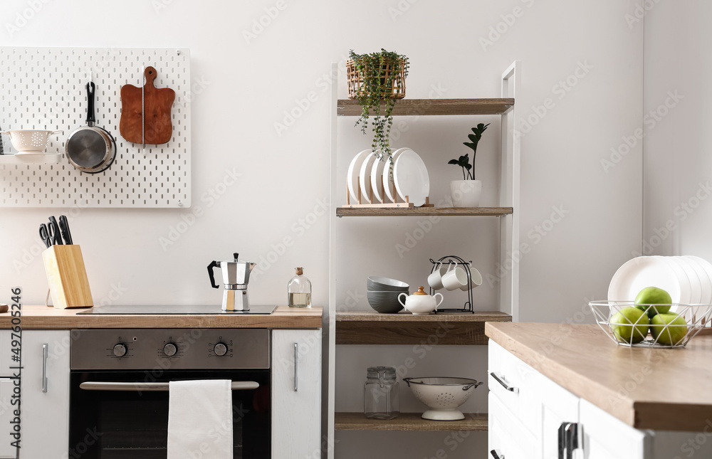 Modern shelving unit with tableware and counters in kitchen