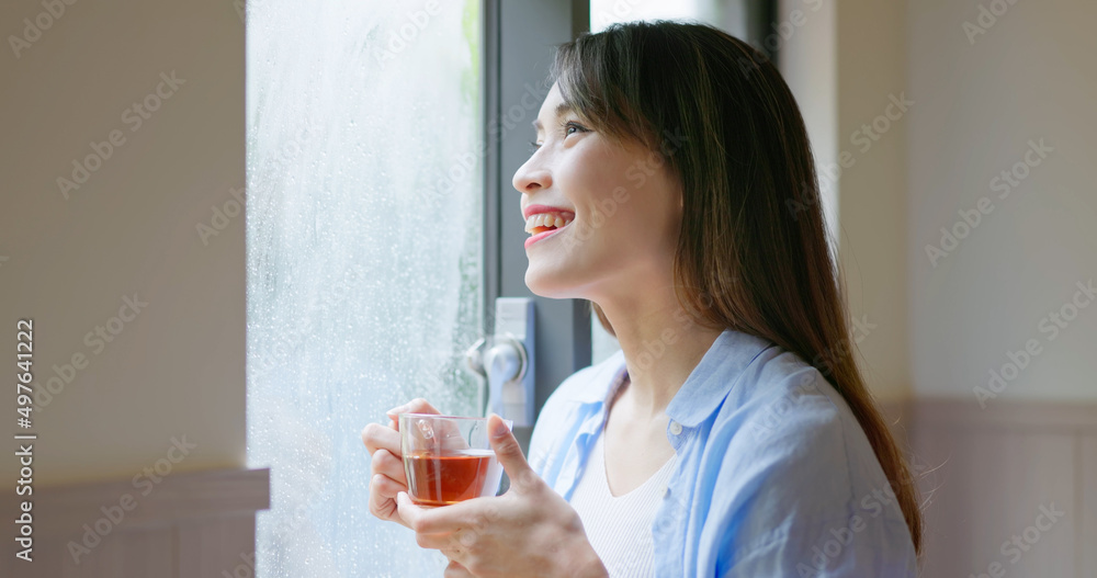 女人透过下雨的窗户看