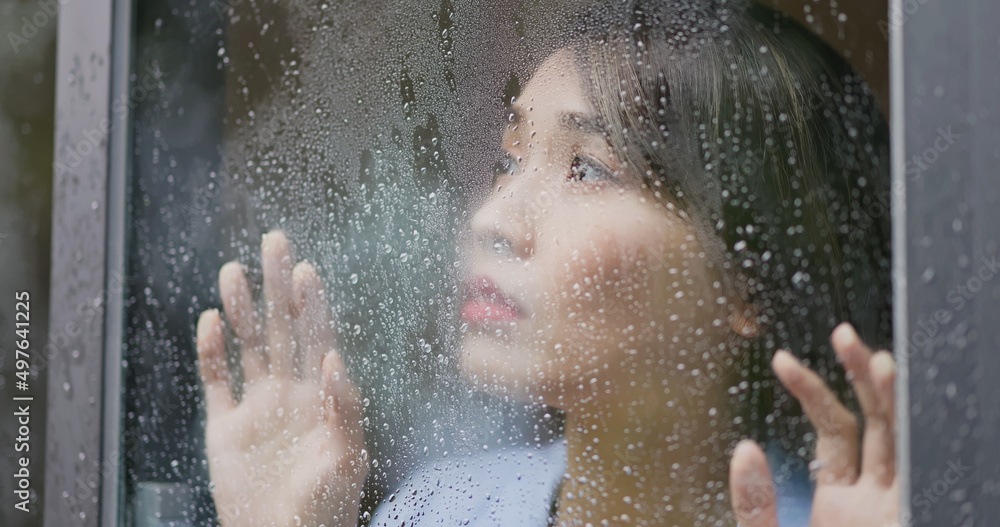 woman behind rainy window