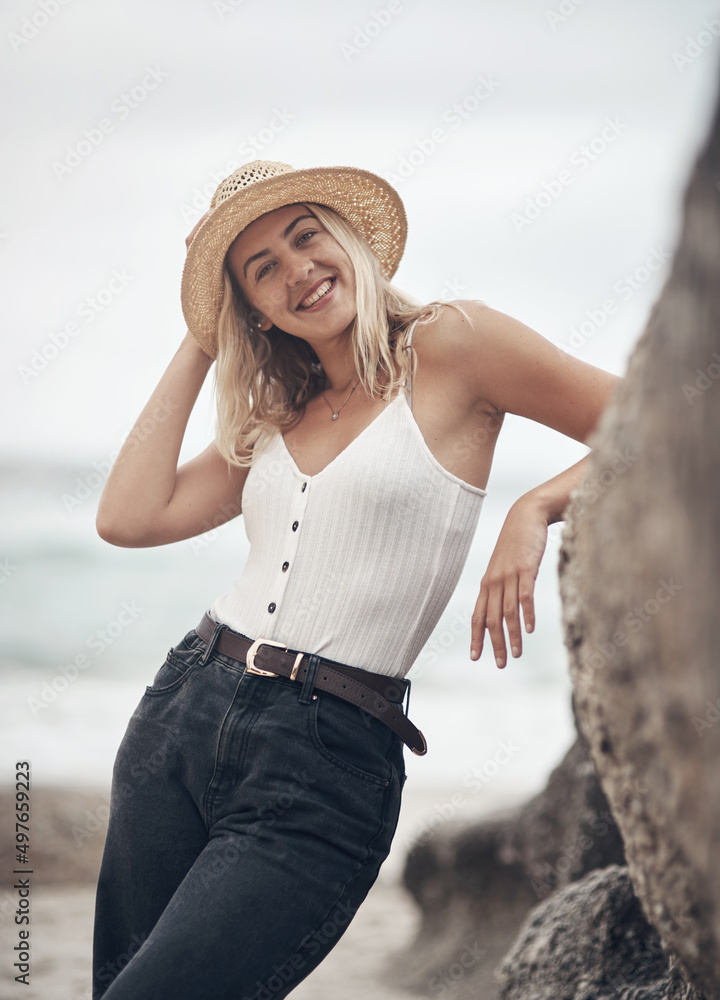 Lets go and get our feet wet. Shot of a beautiful young woman spending the day at the beach.