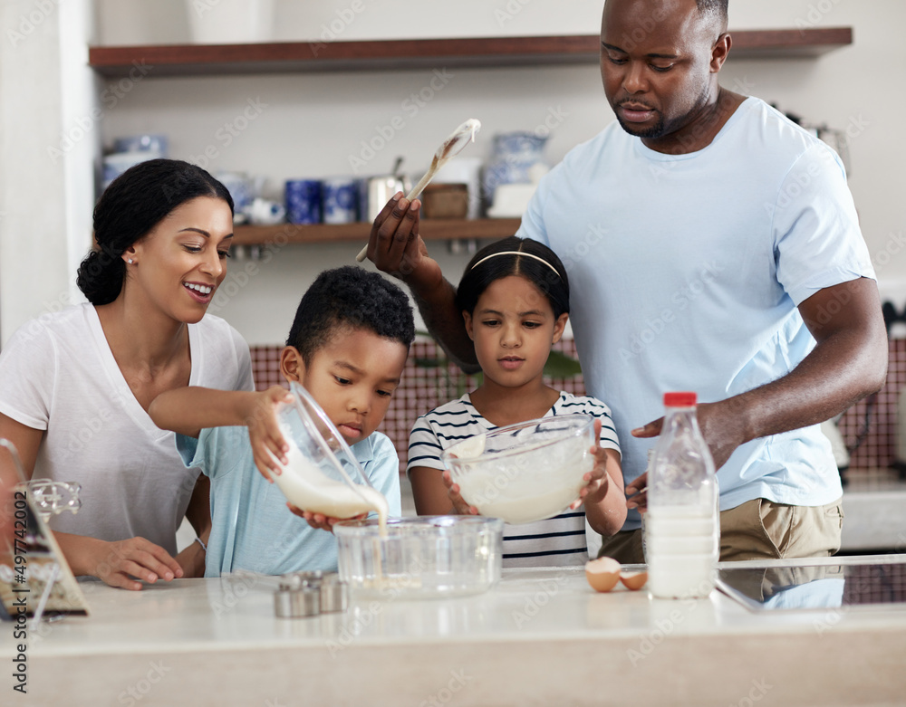 Spending some quality time in the kitchen. Cropped shot of a young family baking together in the kit