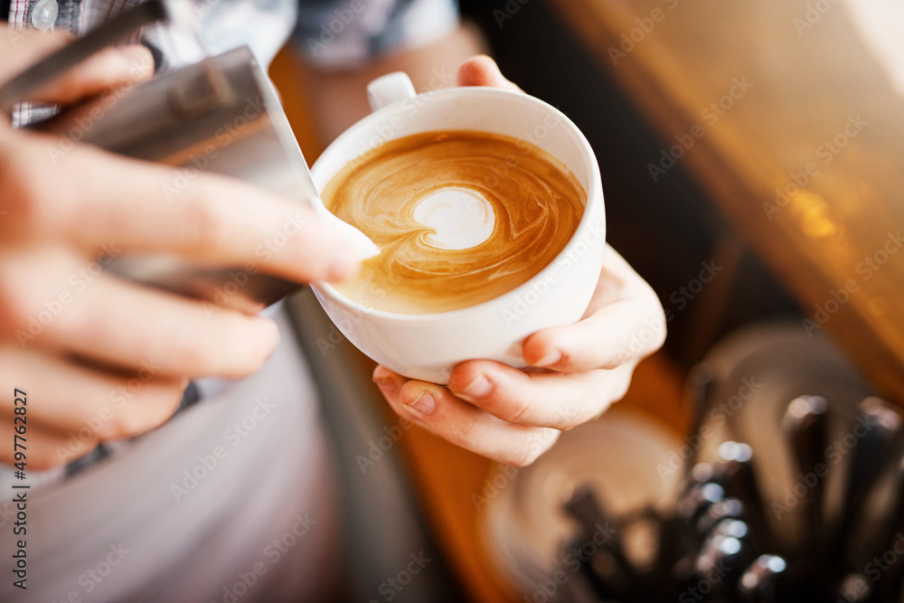 Making pictures. A cropped shot of an unrecognizable barista pouring frothy milk into a cup of hot c