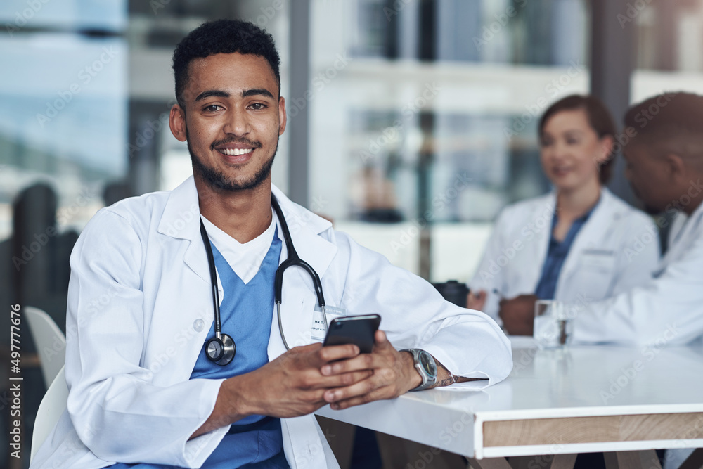 My favourite person just texted me. Shot of a young male doctor using his smartphone while taking a 