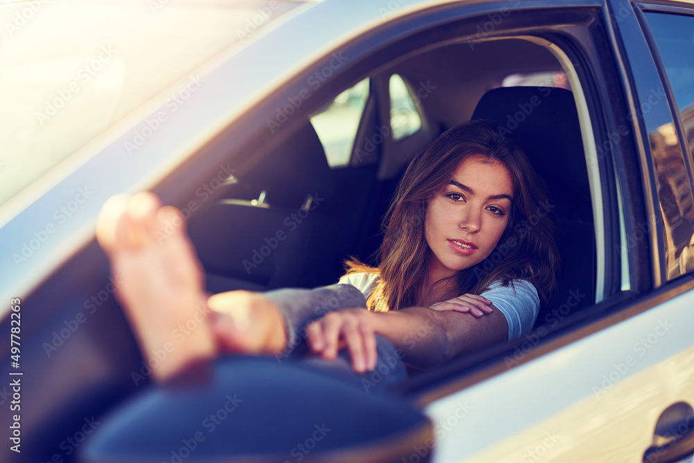 她的公路旅行看起来不错。一张年轻女子坐在车里的照片。