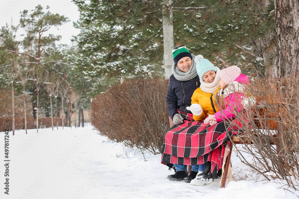 下雪的冬日，小女孩和爷爷奶奶坐在公园里