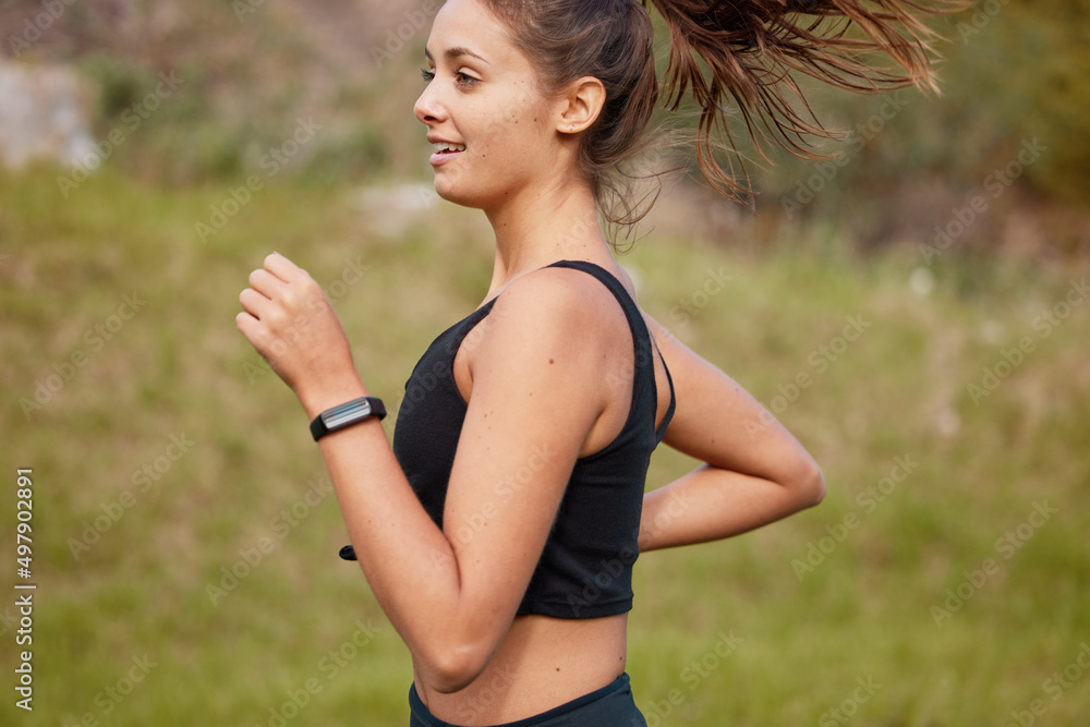 Sprinting straight towards a healthier lifestyle. Shot of a sporty young woman running outdoors.