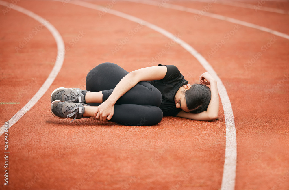 Someone bring me an ice pack. Shot of an athletic young woman suffering from a sports injury while o