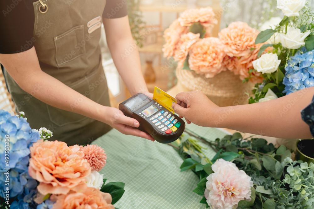 Close up of easy payment by credit card or smartphone application Greenhouse workers selling pottere