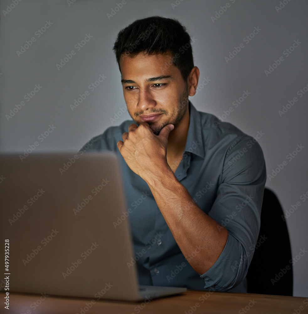 Working from home as a boss. Shot of a confident young man working on a laptop in the office at nigh