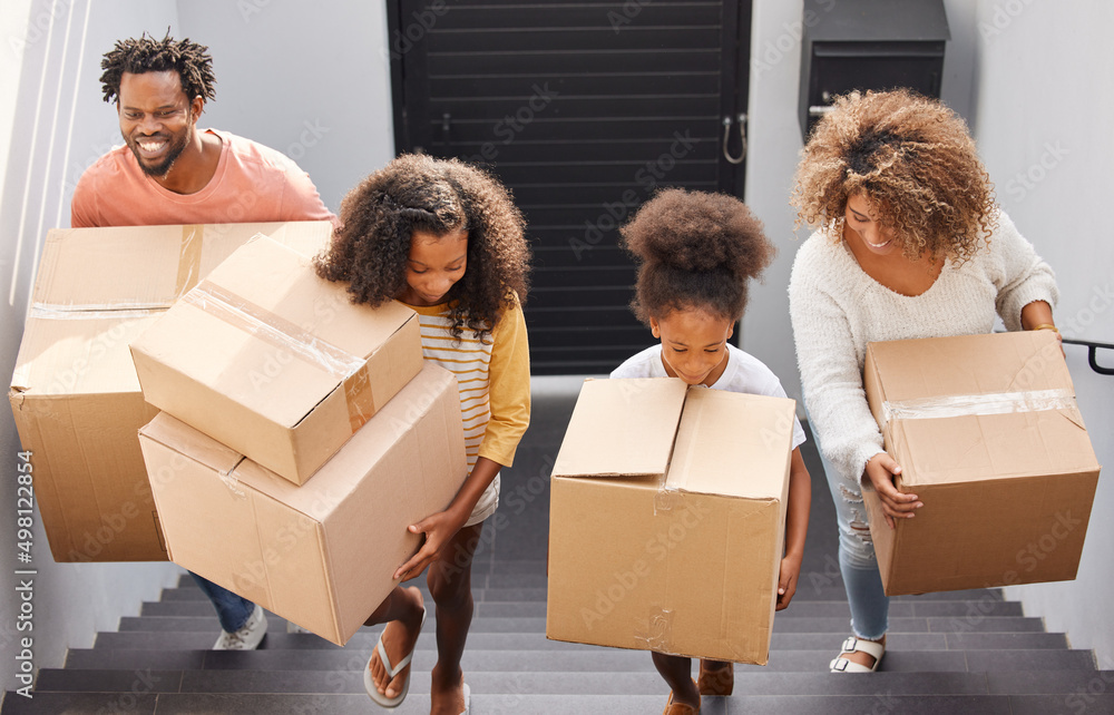 Theres nothing more important than a good, safe, secure home. Shot of a family carrying boxes into t