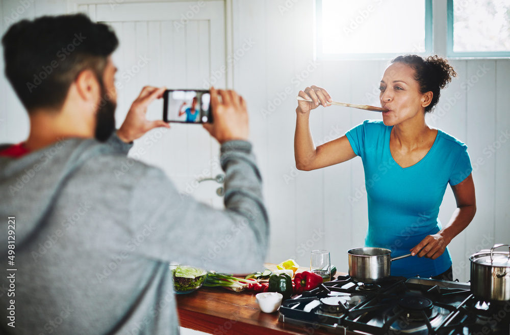 All of the taste, none of the calories. Shot of a man filming his wife on his smartphone while she c