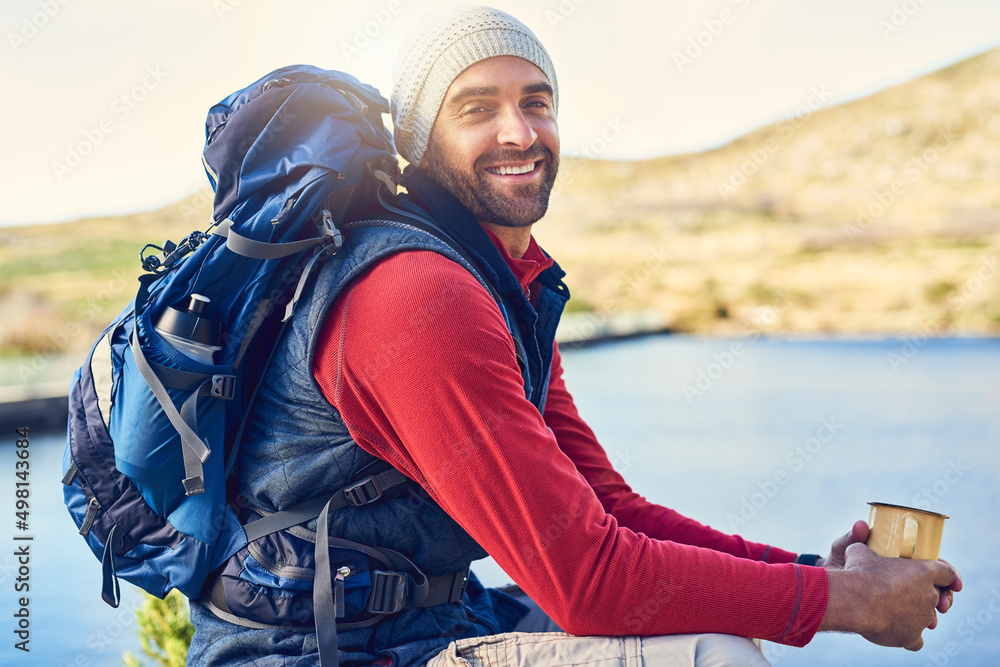 All I need is coffee and a view. Portrait of a happy hiker drinking coffee while admiring a lake vie