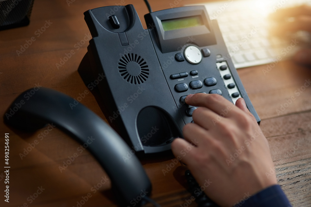 Make that call. Cropped shot of an unrecognizable man dialling a number on a telephone.