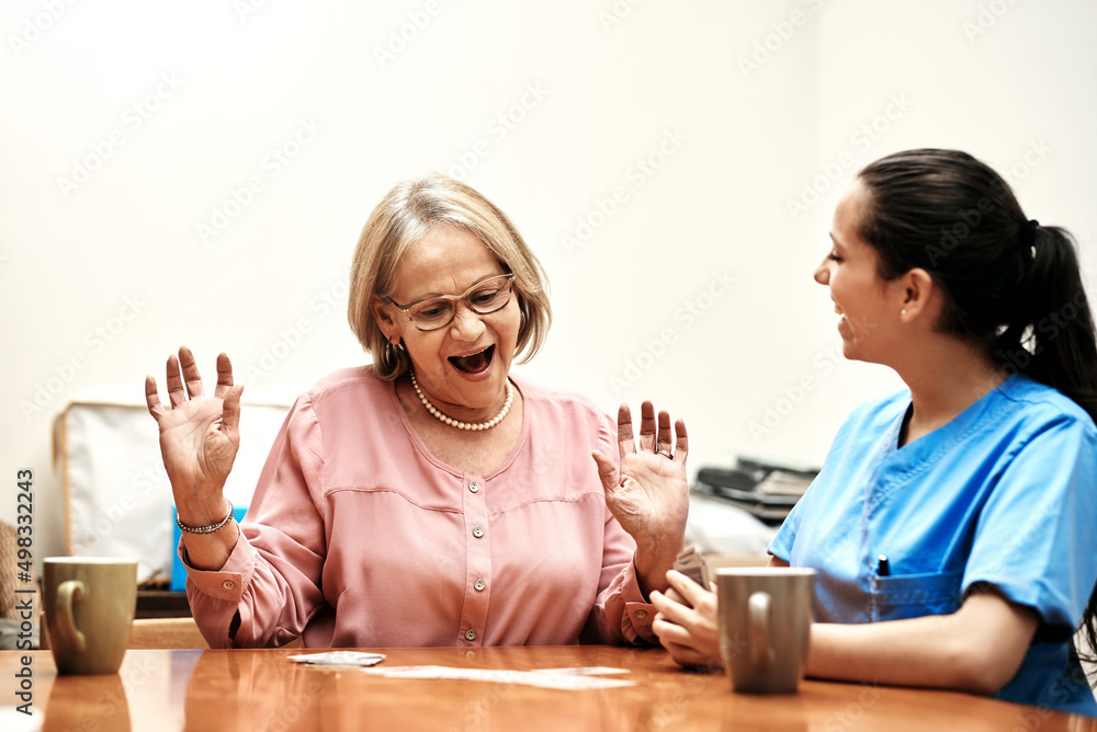 I told you Im better at this. Cropped shot of a senior woman playing cards with her caregiver.