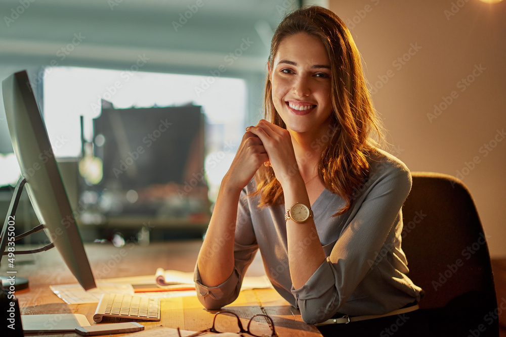 加班有好处。一位魅力四射的年轻女商人在办公室加班的画像